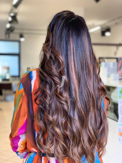 Foto di donna con capelli lunghi castano scuro mogano o violino