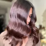 Foto di donna con capelli lunghi castano scuro mogano o violino