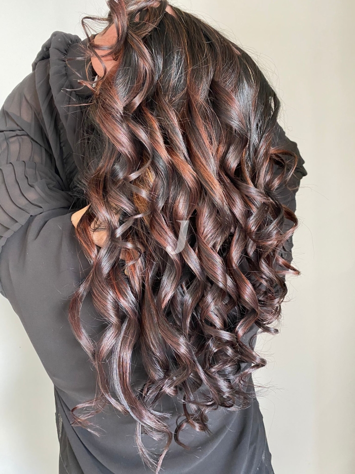 Foto di donna con capelli lunghi castano scuro mogano o violino