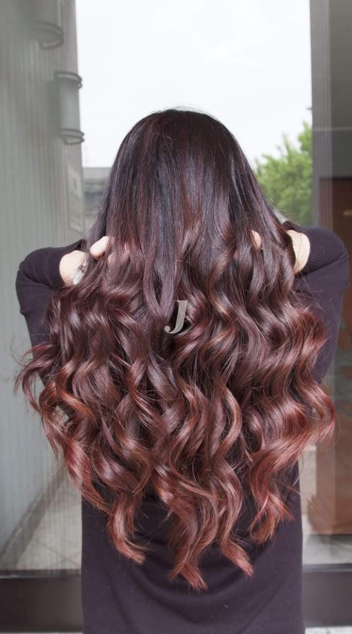 Foto di donna con capelli lunghi castano scuro mogano o violino