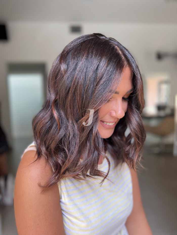 Foto di donna con capelli medi castano scuro mogano o violino