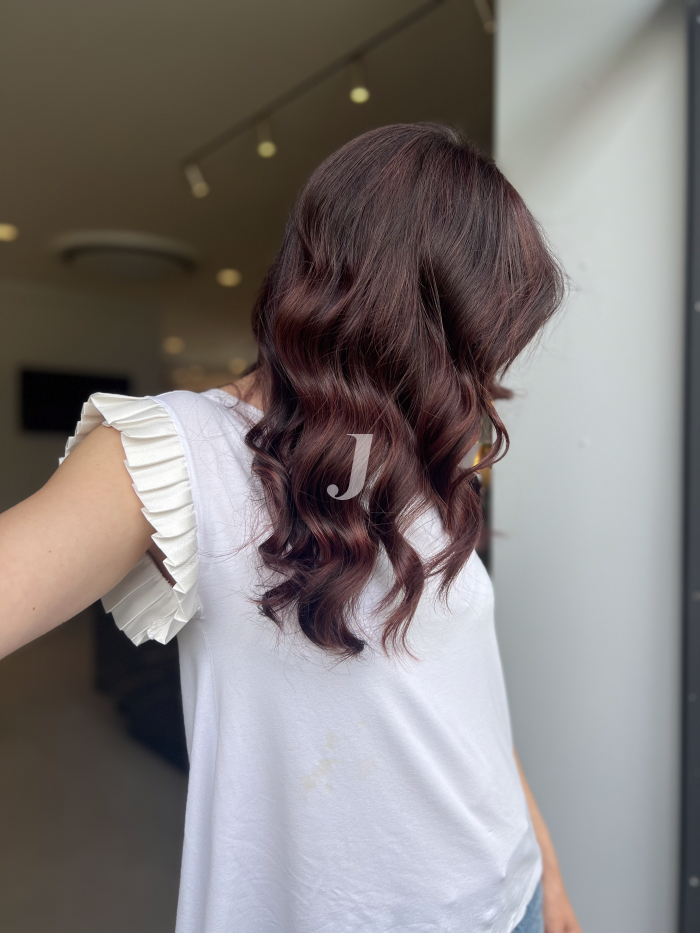 Foto di donna con capelli medi castano scuro mogano o violino